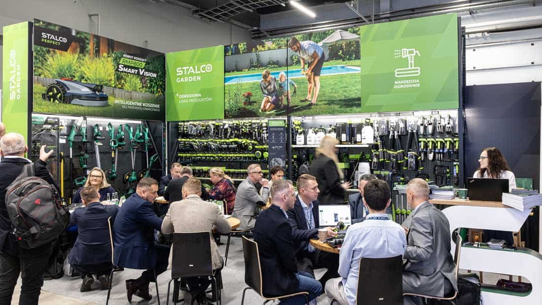 Duże stoisko STALCO GARDEN z linią produktów ogrodniczych, w tym robotem koszącym i narzędziami. Liczni partnerzy PSB prowadzący intensywne rozmowy biznesowe przy stolikach targowych.