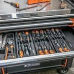 Szuflada wózka narzędziowego RICHMANN z wkrętakami, szczypcami i dodatkowymi narzędziami ręcznymi podczas pracy w warsztacie.