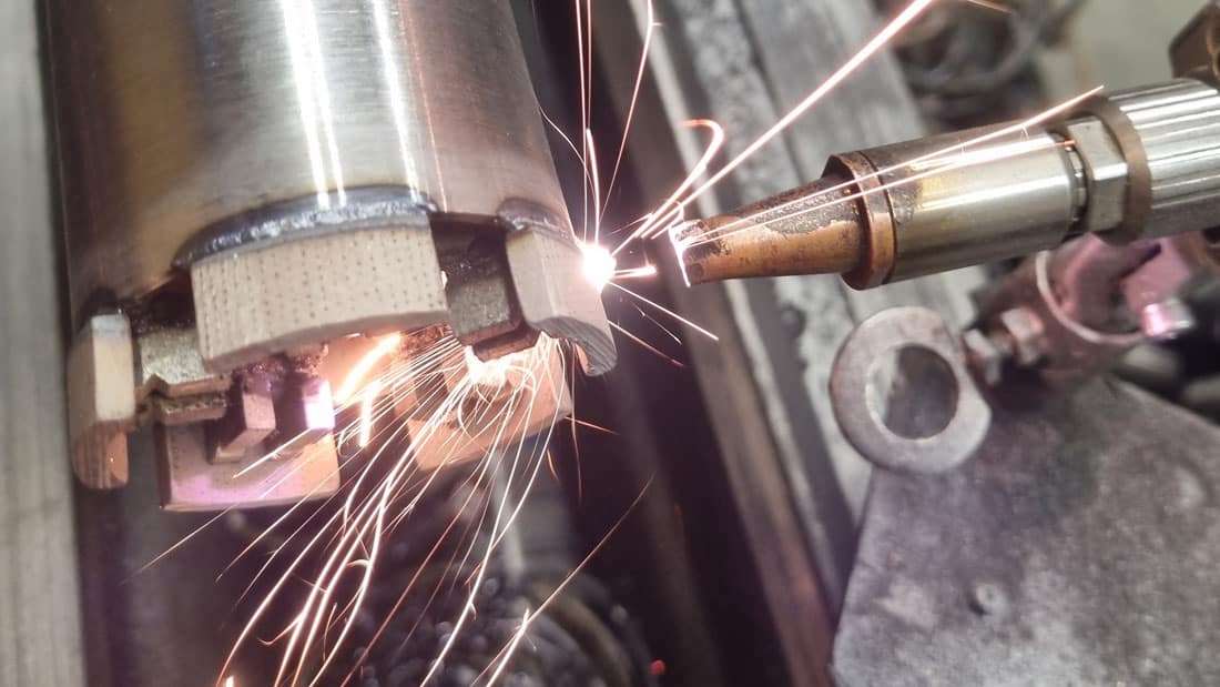 Nowoczesna produkcja korony diamentowej Adiam: spawanie segmentu diamentowego do korpusu za pomocą technologii laserowej. Iskry podczas precyzyjnego łączenia.