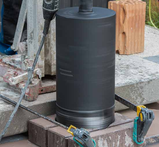 Korona diamentowa Kinczyk KWK-B osadzona w betonie podczas wykonywania otworu przebiciowego metodą wiercenia diamentowego