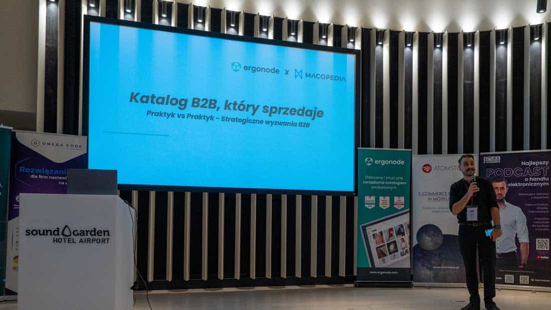 Prelegent na scenie na tle prezentacji "Katalog B2B, który sprzedaje", współorganizowanej przez firmy Ergonode i Macopedia.