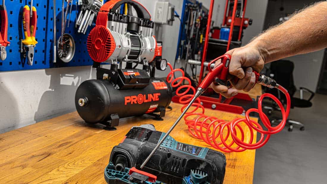 Bezolejowy kompresor PROLINE P200003 w warsztacie – zasilanie pistoletu pneumatycznego do czyszczenia narzędzi