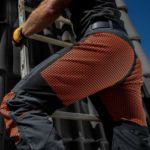 Zbliżenie na spodnie robocze LAHTI PRO noszone przez dekarza podczas pracy na wysokości na dachu