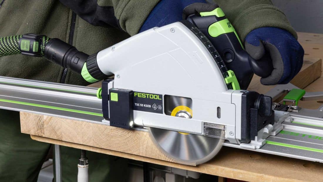 Akumulatorowa zagłębiarka Festool TSC 55 KSEB podczas cięcia litego drewna na szynie prowadzącej FS