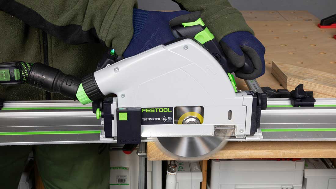 Akumulatorowa zagłębiarka Festool TSC 55 KSEB podczas cięcia litej belki na szynie prowadzącej FS