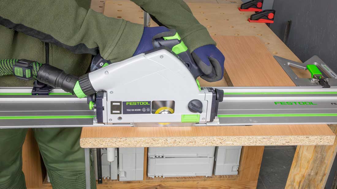 Zagłębiarka akumulatorowa Festool TSC 55 KSEB w trakcie precyzyjnego cięcia płyty meblowej na szynie FS