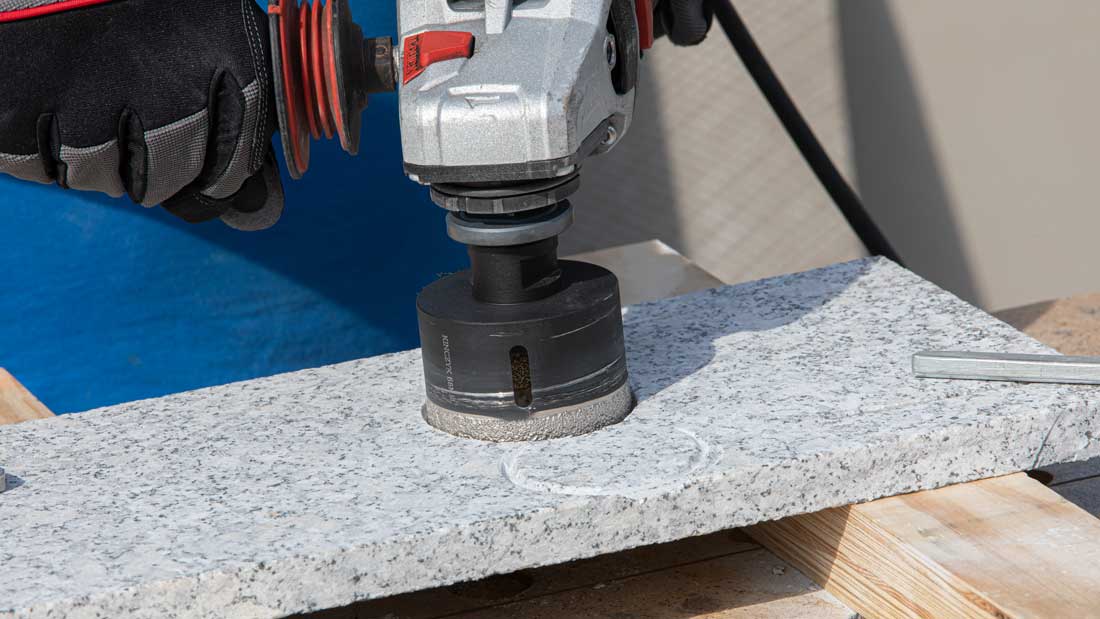 Koronka diamentowa Kinczyk KOD GRES-B wiercąca otwór na sucho w płycie granitowej przy użyciu szlifierki kątowej