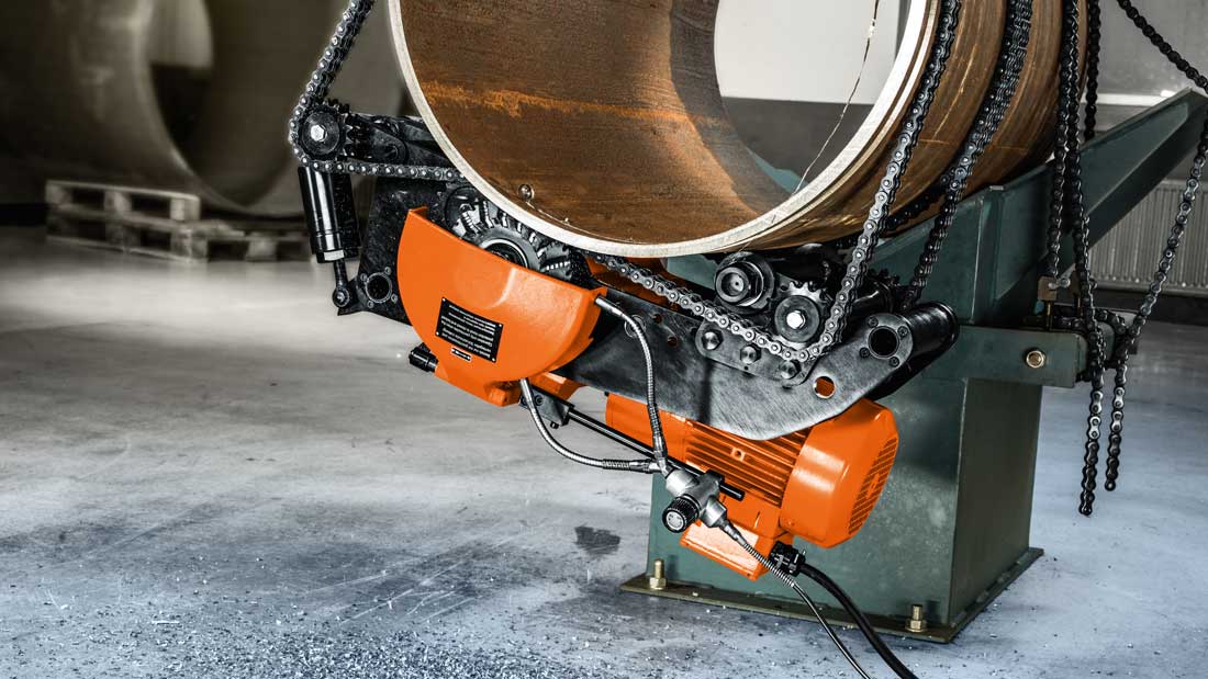 Frezarka do rur FEIN zamocowana łańcuchowo na stalowej rurze podczas obwodowego cięcia przemysłowego