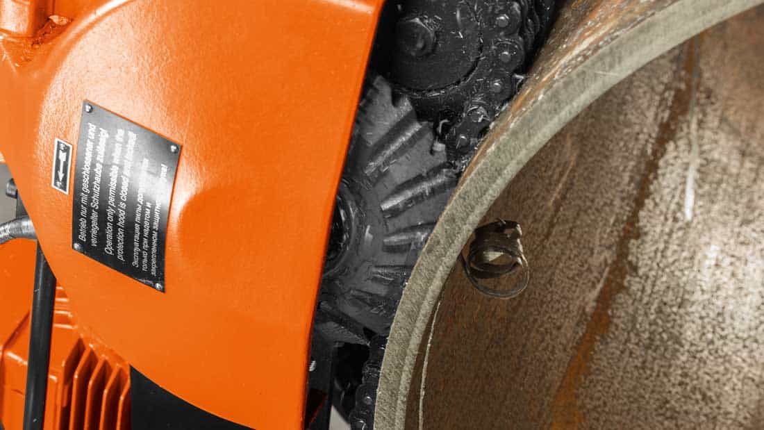 Zbliżenie głowicy frezującej frezarki do rur FEIN podczas obróbki krawędzi stalowego rurociągu