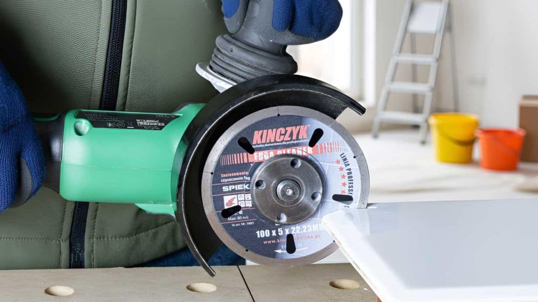 Tarcza diamentowa KINCZYK FUGA CLEANER zamontowana w szlifierce kątowej podczas testowego cięcia – narzędzie przeznaczone do usuwania fug i precyzyjnego formatowania płytek ceramicznych oraz gresowych.