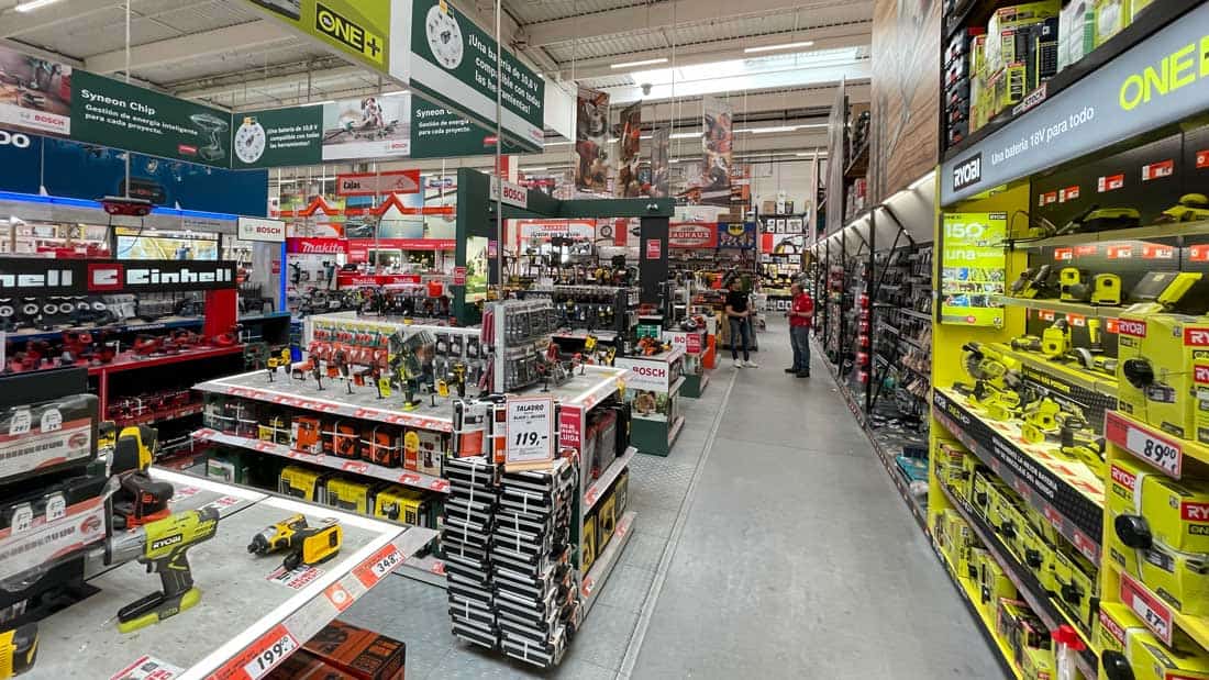 Dział elektronarzędzi w markecie DIY z ekspozycją narzędzi Ryobi, Einhell i Bosch oraz systemów akumulatorowych dla majsterkowiczów.