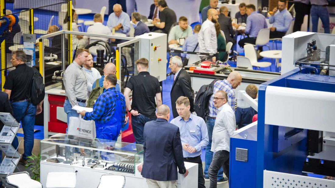 Zwiedzający i wystawcy przy stoiskach z maszynami przemysłowymi podczas targów ITM INDUSTRY EUROPE w Poznaniu.