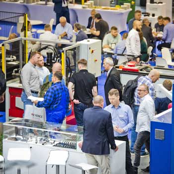 Rozmowy biznesowe przy stoiskach z technologiami przemysłowymi na targach ITM INDUSTRY EUROPE.