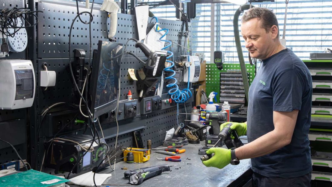 Technik Centralnego Serwisu Festool podczas naprawy elektronarzędzia przy specjalistycznym stanowisku diagnostycznym.