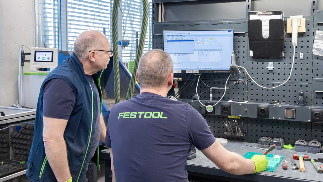 Pracownicy Centralnego Serwisu Festool analizują dane diagnostyczne elektronarzędzia na stanowisku komputerowym.