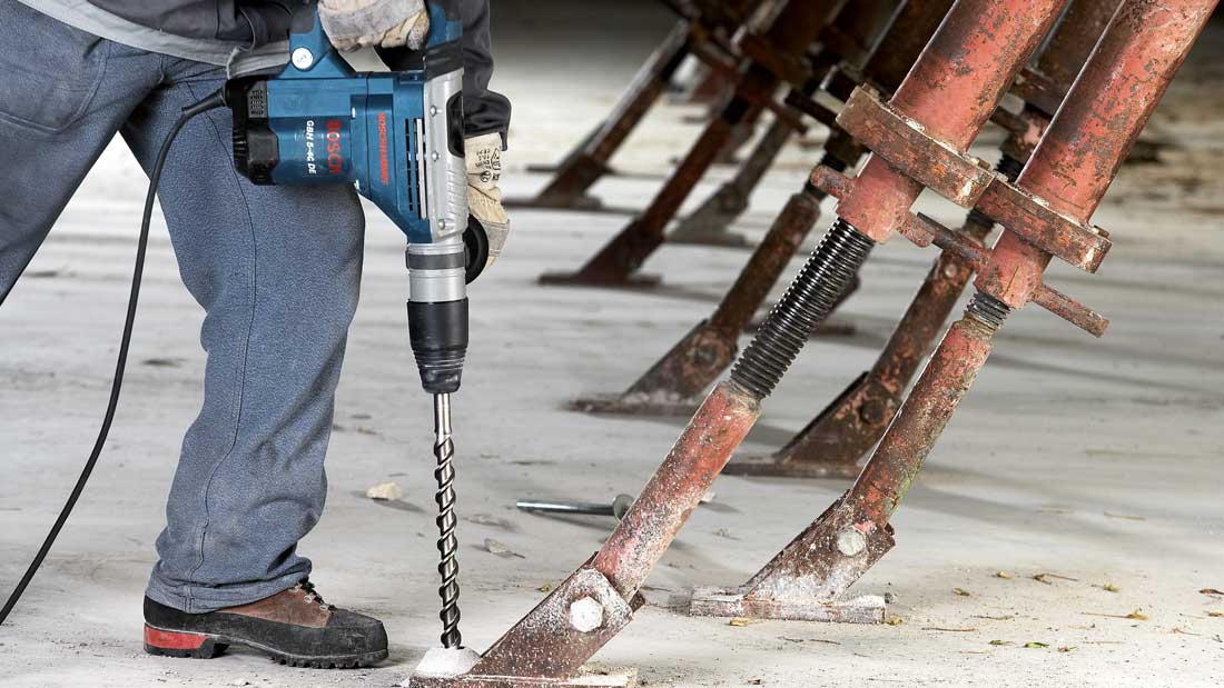 Wiercenie w betonie młotem udarowo-obrotowym Bosch Professional podczas prac budowlanych przy konstrukcji.